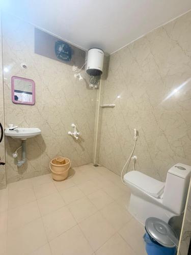 a bathroom with a toilet and a sink at VR Jardin Resort in Pondicherry