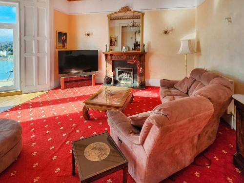 a living room with a couch and a fire place at Riviera Mansion, Torquay in Torquay