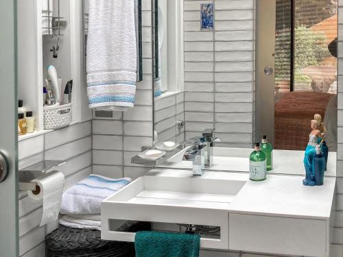 a bathroom with a white sink and a window at The Studio in Wingham