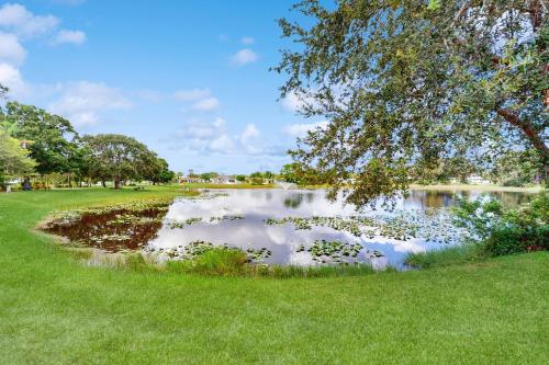 a pond in a park with a tree and grass at Sebastian Serenity in Sebastian