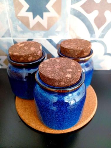 three blue glass jars with cookies on top of them at Topaze - En plein coeur de la ville Dijon in Dijon