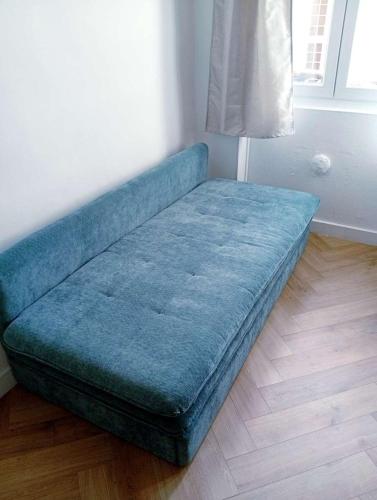 a blue couch sitting on the floor in a room at Topaze - En plein coeur de la ville Dijon in Dijon
