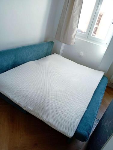 a mattress on the floor in a room with a window at Topaze - En plein coeur de la ville Dijon in Dijon