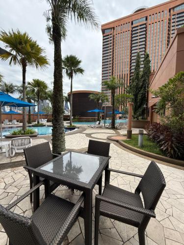 a patio with a table and chairs and palm trees at Times Square KL Serviced Suite in Kuala Lumpur