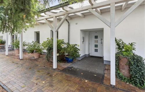 a white building with potted plants in front of it at Cottage in Gransee