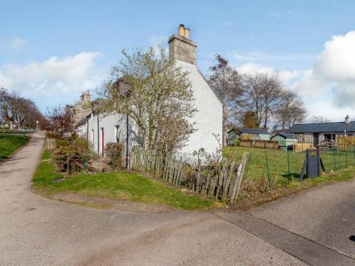 una casa blanca con una valla al lado de una calle en 19 South Street, en Grantown-on-Spey