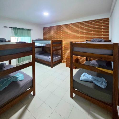 Zimmer mit 3 Etagenbetten und Ziegelwand in der Unterkunft Tucacas, Frente al Mar, Vista a la Piscina y Playa Privada in Boca de Aroa