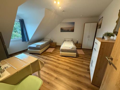 a room with two beds and a desk and a table at Gavner Boardinghouse Apen in Apen