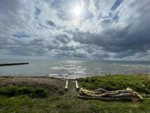 a bench sitting on the shore of the ocean at Sunrise Summerhouse in Hilton of Cadboll