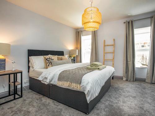 a bedroom with a large bed and a chandelier at Upper Deck in Saint Erth