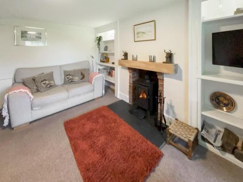 a living room with a couch and a fireplace at Court End Cottage in Silecroft