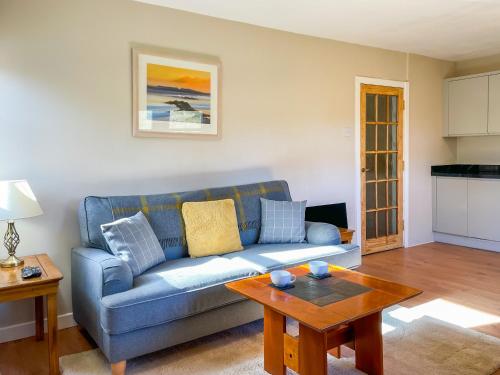 a living room with a blue couch and a table at Innish Beag - Uk38782 in Clachan