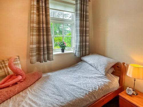 a small bedroom with a bed and a window at Estate Cottage in Wheldrake