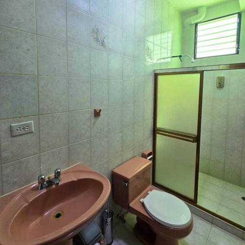 ein Badezimmer mit Waschbecken, Toilette und Dusche in der Unterkunft Tucacas, Frente al Mar, Vista a la Piscina y Playa Privada in Boca de Aroa