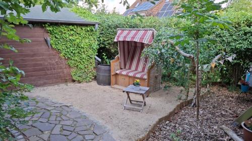 a garden with a red chair with a canopy at Großes Ferienhaus Dagebüll mit Kamin in Dagebüll