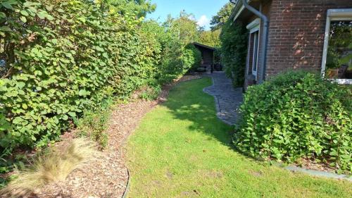 a walkway next to a brick building next to a yard at Großes Ferienhaus Dagebüll mit Kamin in Dagebüll
