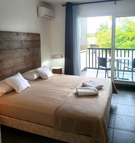 a bedroom with a large bed and a balcony at Golf Marin in Saint-François