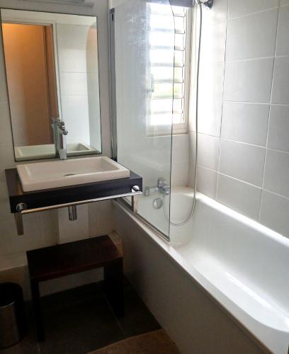 a bathroom with a sink and a tub and a mirror at Golf Marin in Saint-François