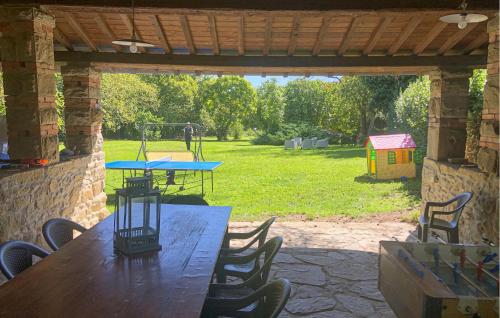 a wooden table with chairs and a playground in a yard at Nice Home In Pratovecchio Stia in Borgo alla Collina