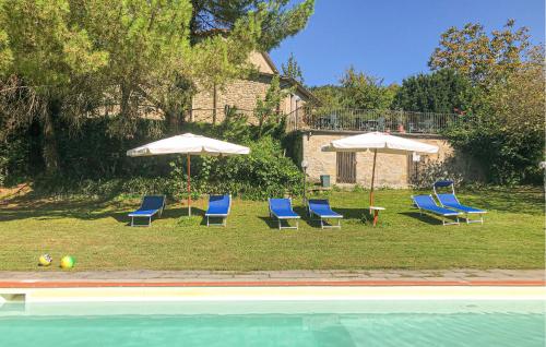 a group of chairs and umbrellas next to a pool at Nice Home In Pratovecchio Stia in Borgo alla Collina