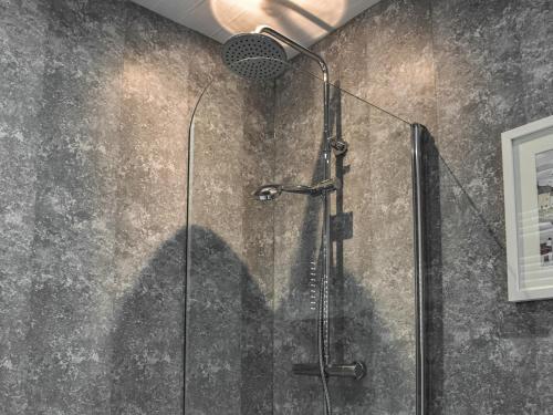 a shower stall with a shadow on a wall at Kingfishers Rest in Millom
