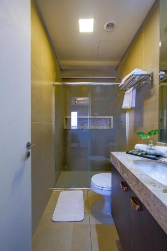 a bathroom with a shower and a toilet and a sink at Excelente Flat Moderno e espaçoso no Cittyplex Osasco in Osasco