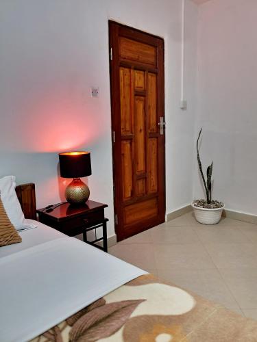 a bedroom with a bed and a table with a lamp at Faraja Homestay Mwanza in Mwanza