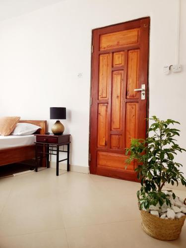 a room with a door and a bed and a plant at Faraja Homestay Mwanza in Mwanza