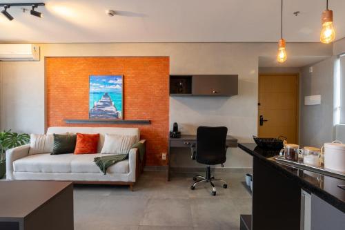 a living room with a couch and a desk at Excelente Flat Moderno e espaçoso no Cittyplex Osasco in Osasco