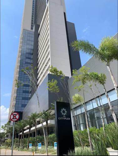 a tall building with a sign in front of it at Excelente Flat Moderno e espaçoso no Cittyplex Osasco in Osasco