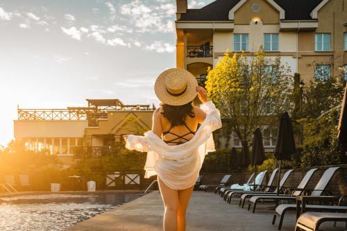 a woman in a white dress and hat standing by a pool at Hotel Chateau Bromont in Bromont