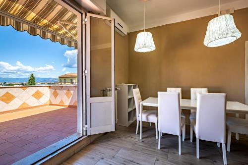 a dining room with a table and chairs and a balcony at YD penthouse Torregalli in Scandicci