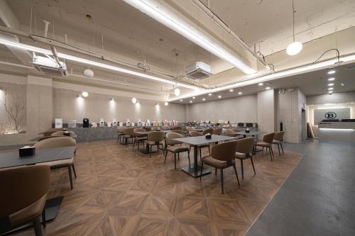 a restaurant with tables and chairs in a room at Browndot Incheon Airport New City in Incheon