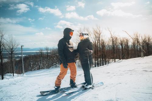 two people standing on skis in the snow at Hotel Chateau Bromont in Bromont