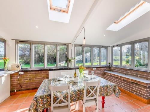 ein Esszimmer mit Tisch und Stühlen und Fenstern in der Unterkunft The Owl Barn - Uk48736 in Gaerwen