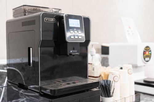 a black coffee maker sitting on top of a counter at Browndot Incheon Airport New City in Incheon