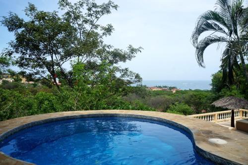 a swimming pool with a view of the ocean at Casa Monacita in Tamarindo