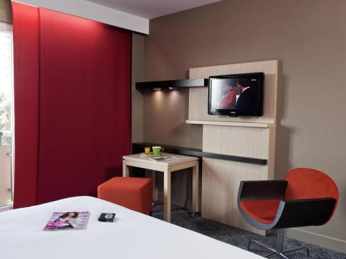 a room with a bed and a tv on a wall at ibis Styles Saint Dizier in Saint-Dizier