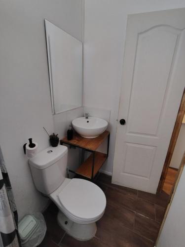 a bathroom with a white toilet and a sink at Atakama loft habitación in Caldera