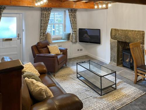 a living room with a couch and a fireplace at Candy Cottage in Addingham