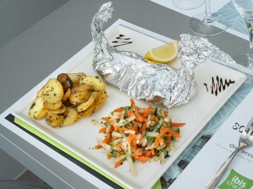a plate of food with potatoes and vegetables on a table at ibis Styles Saint Dizier in Saint-Dizier