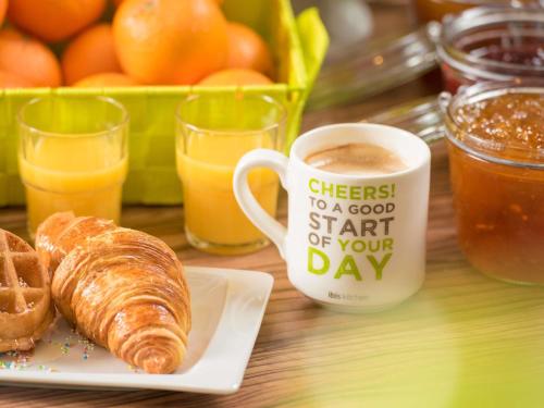 a table with a cup of coffee and a plate of croissants at ibis Styles Saint Dizier in Saint-Dizier