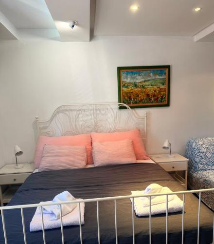 a bedroom with a bed with pink and orange pillows at Natalie Apartment in Niš