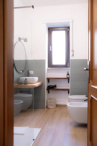 a bathroom with two toilets and a sink and a mirror at Tirituffo - B&B di campagna in Soveria Mannelli