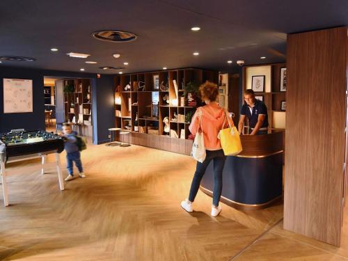 a woman standing at a counter in a store at ibis Styles Nantes Reze Aéroport in Rezé
