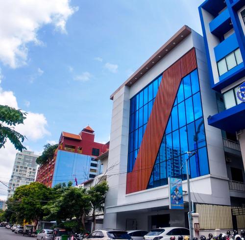 un edificio con ventanas de cristal en una calle de la ciudad en DLSD Hotel, en Phnom Penh