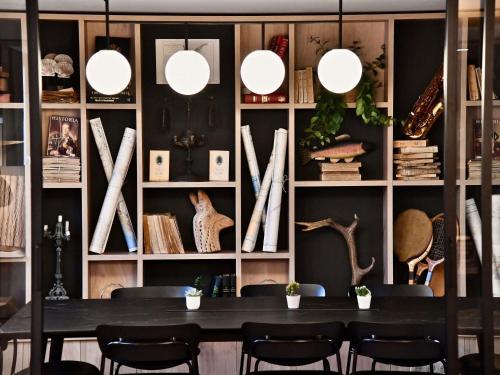 a dining room with a black table and chairs at ibis Styles Nantes Reze Aéroport in Rezé