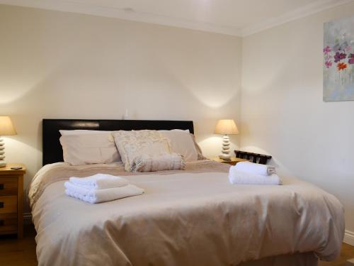 a bedroom with a large bed with towels on it at Ty Glyndwr in Ystalyfera