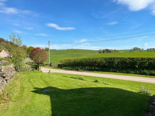 una sombra de una persona en un campo de hierba en Kilquhanity Cottage, en Castle Douglas