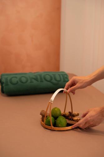 a person holding a basket of limes on a table at Iconique Hotel Nha Trang in Nha Trang